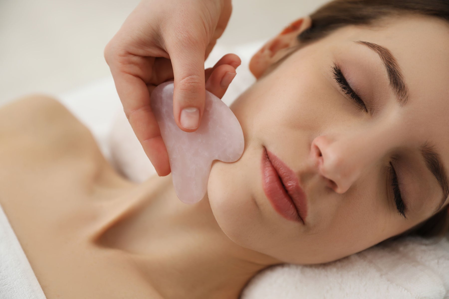 Lady lying down with face massage